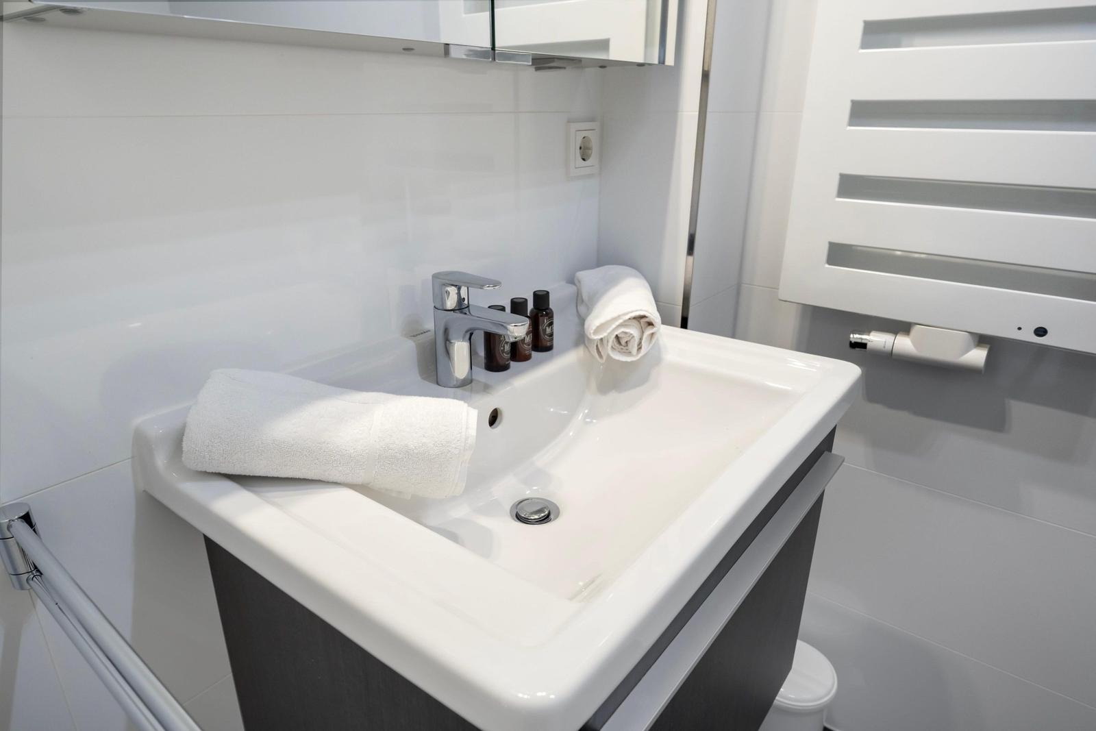 Sink with towel, mirror, and heater