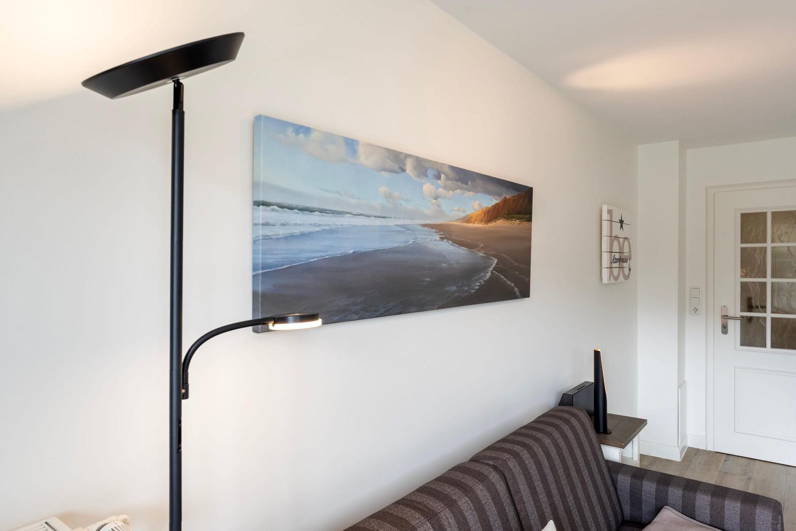 Living room with sofa, floor lamp, and wall picture