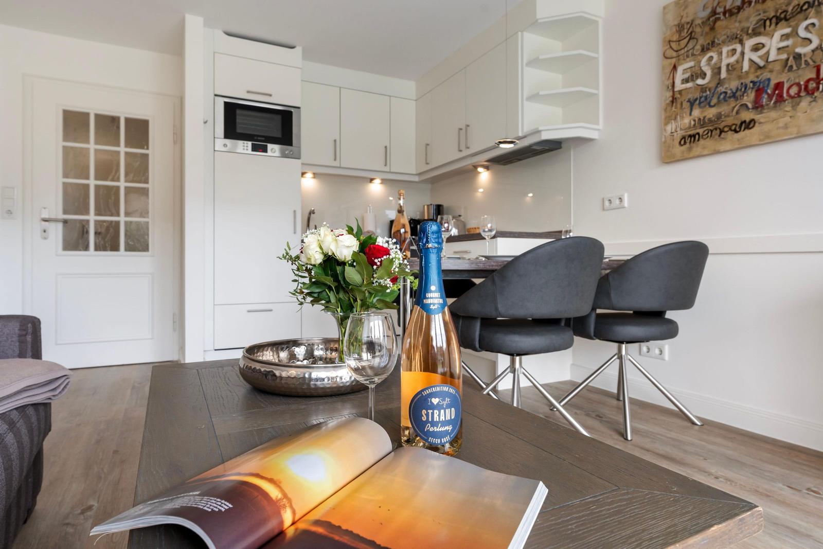 Dining area with table, chairs, and kitchen in background
