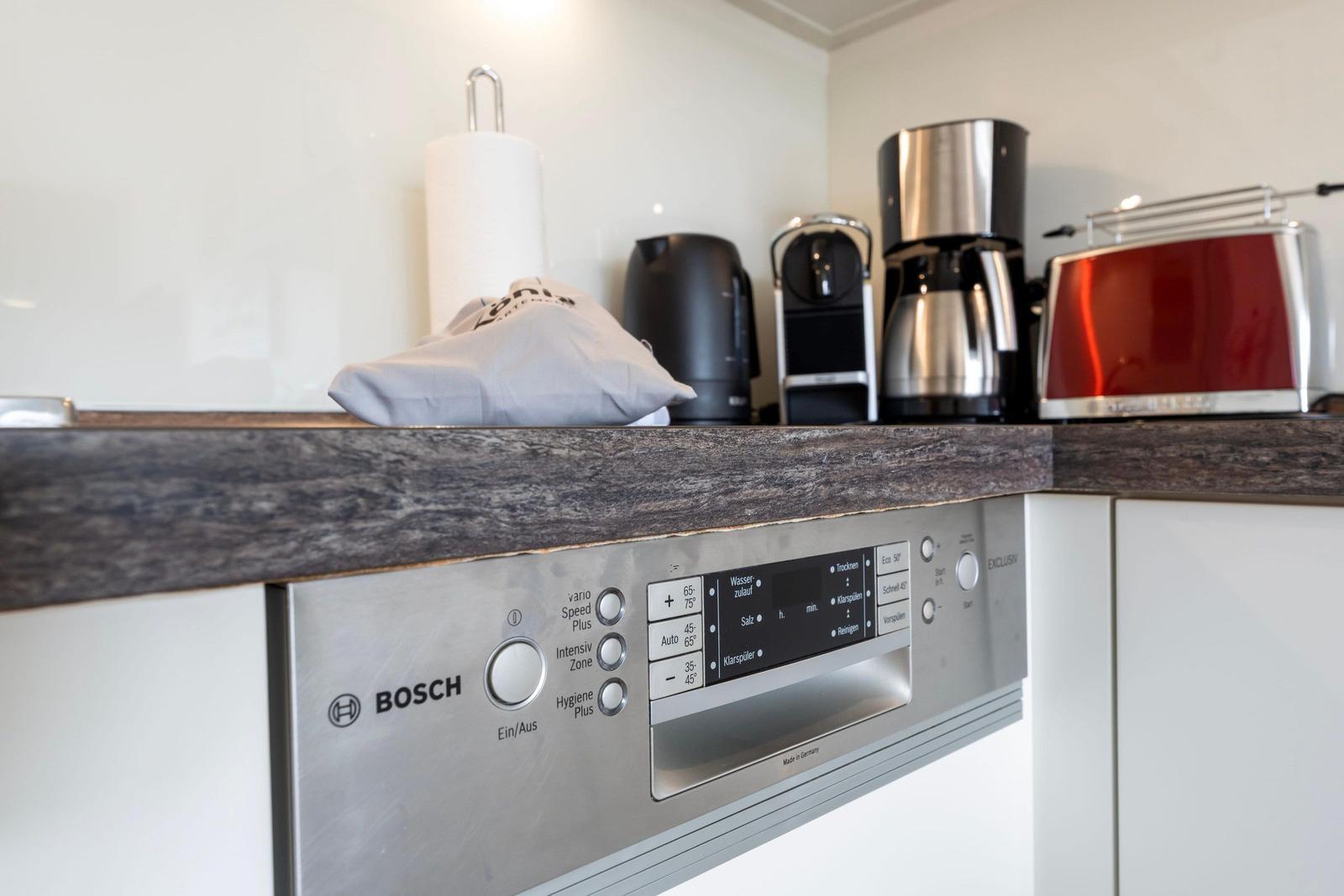 Kitchen counter with dishwasher, coffee machine, and toaster.