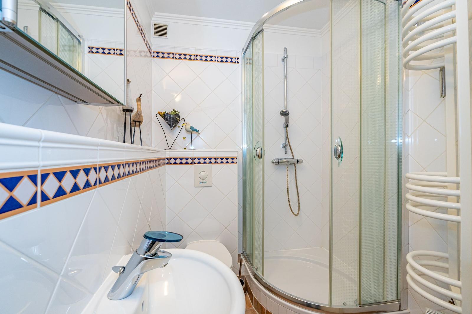 Bathroom with shower, sink, and heater