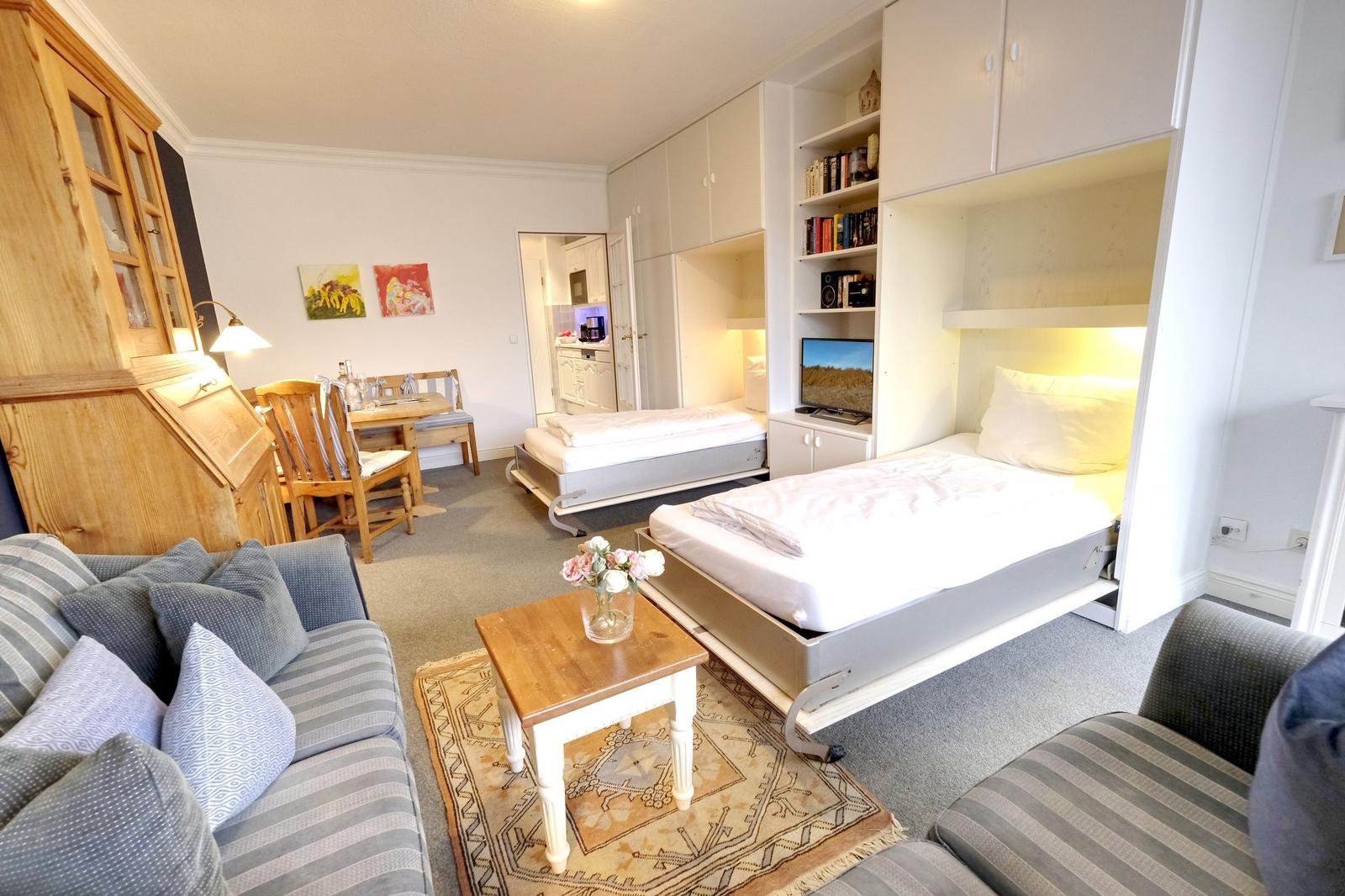 Zimmer mit zwei Betten, Wohnbereich, Esstisch und Küchenbereich.