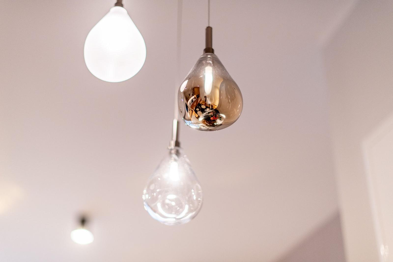 Three hanging lamps with different glass bodies illuminate the room.