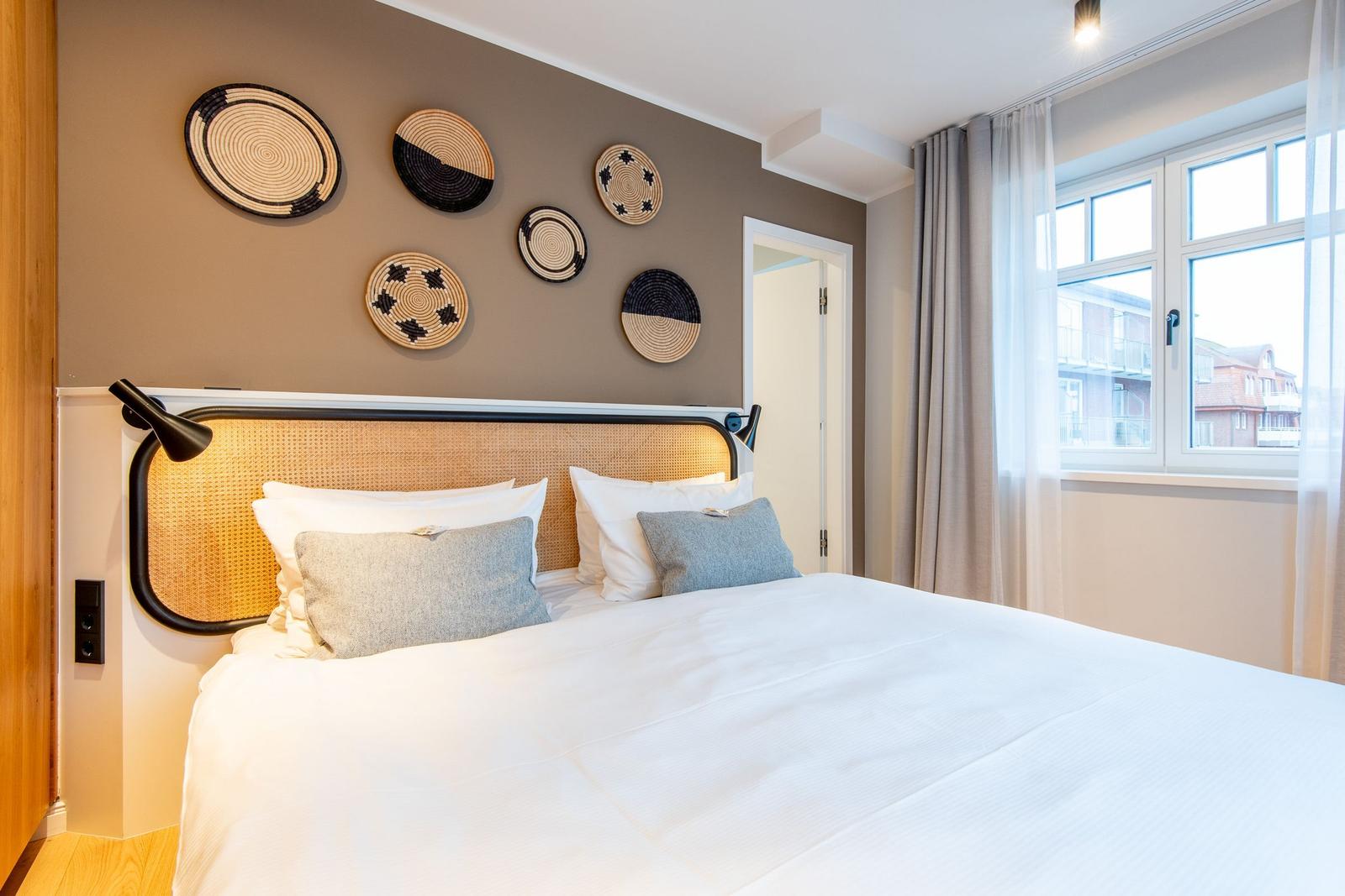 Bedroom with bed, wall decor, and window view.
