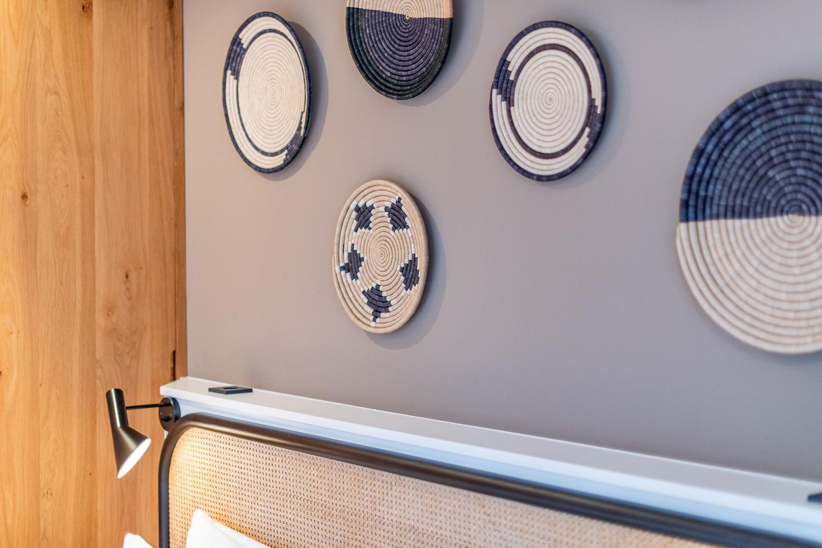 Wall with decorative woven baskets above the bed