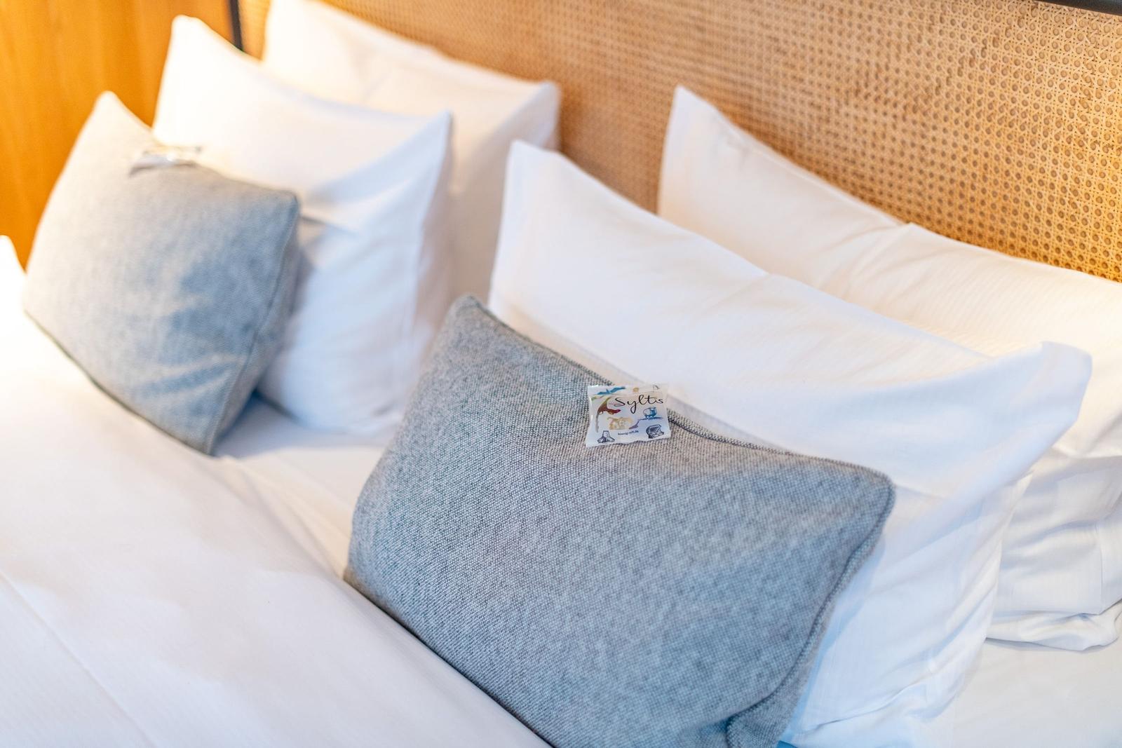 Headboard with woven pattern and pillows in white and gray