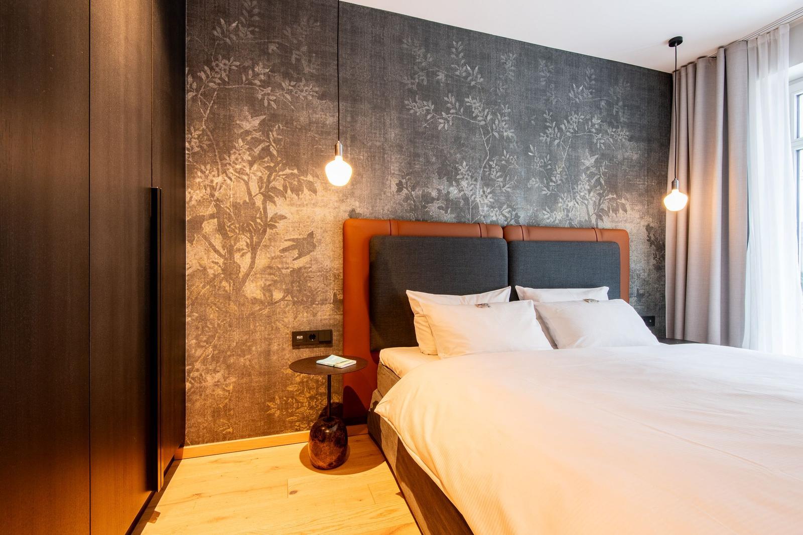 Schlafzimmer mit Bett, Wandtapete und Nachttisch