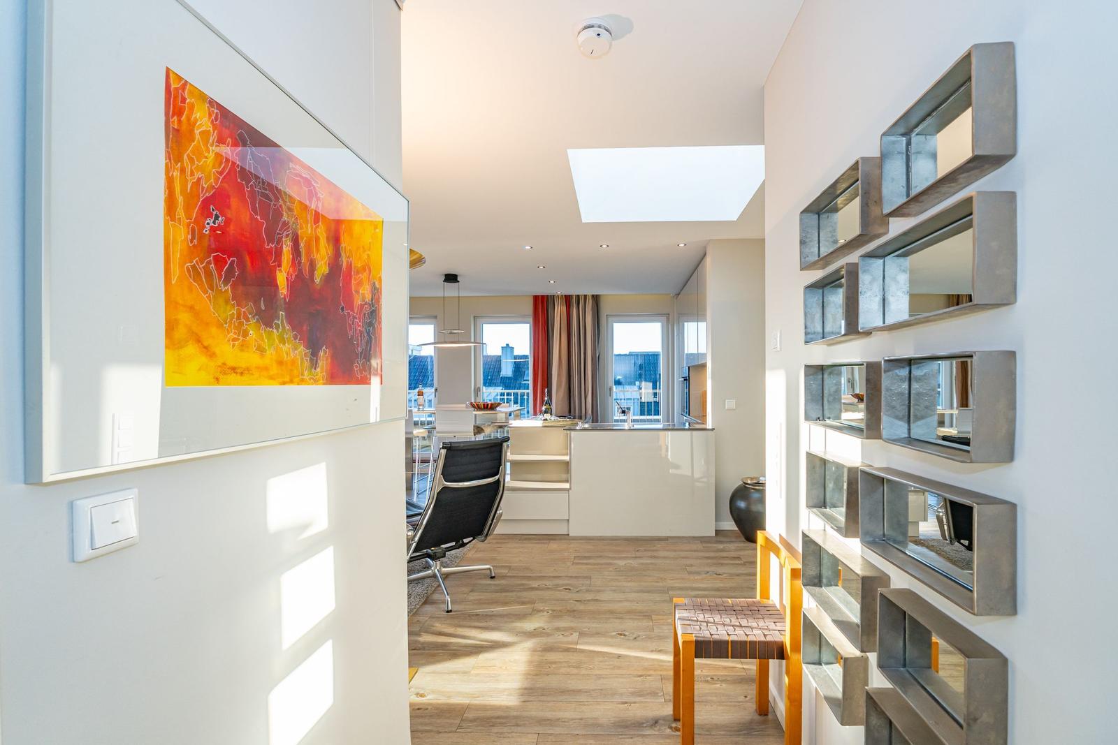 Moderne Wohnung mit Skylight, Kücheninsel und Wanddekoration.