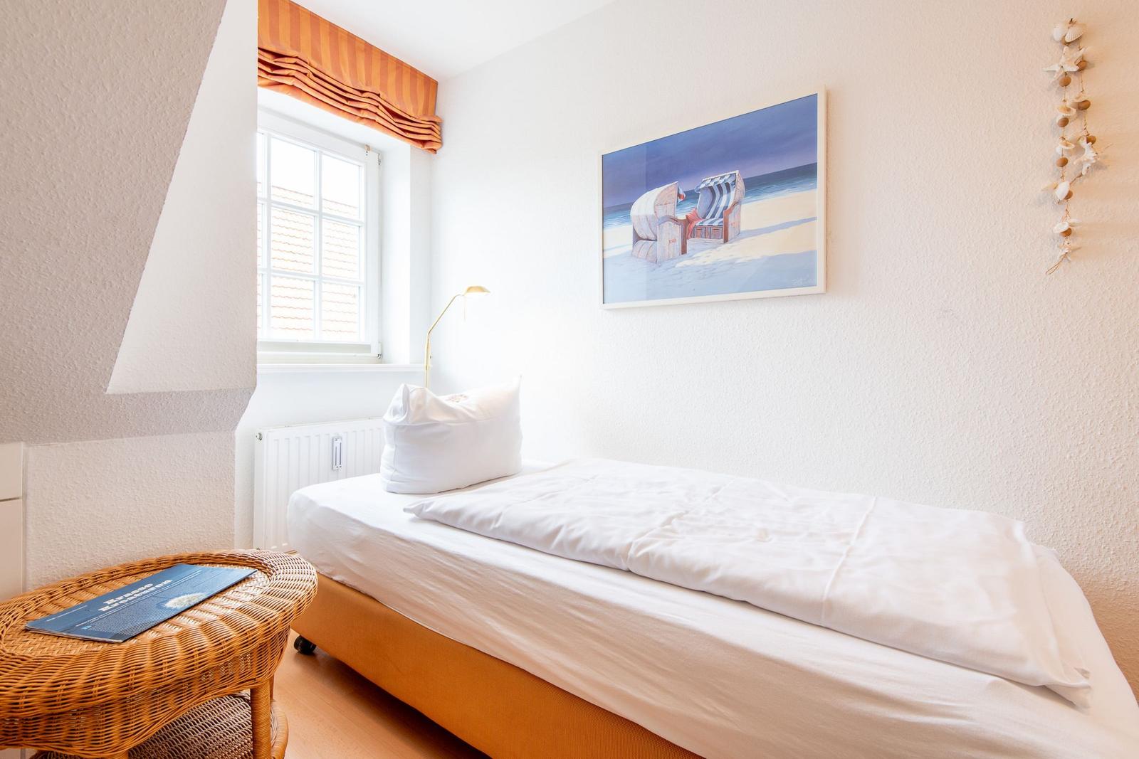 Ein Schlafzimmer mit einem Bett, einem Fenster und einer Wanddekoration.