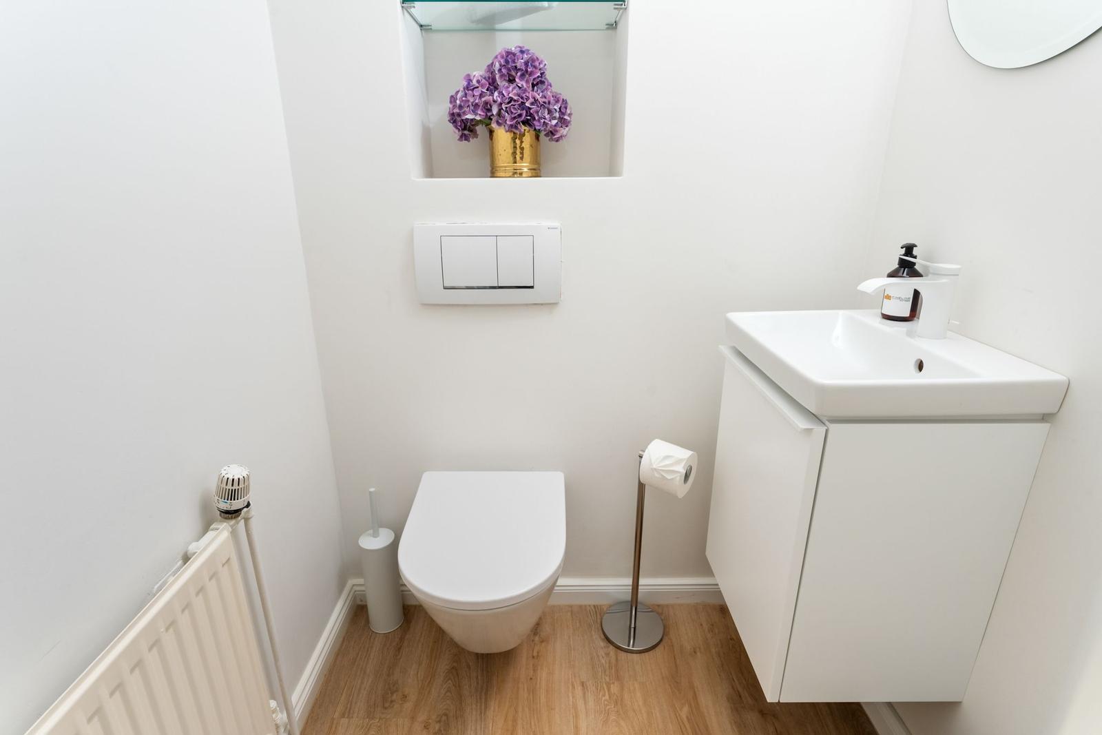 Badezimmer mit Toilette, Waschbecken und Holzboden