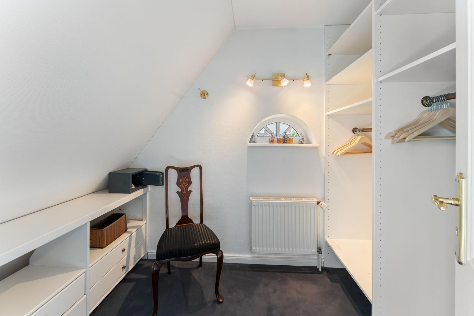 Schlafzimmer mit Kleiderschrank, Stuhl und Fenster