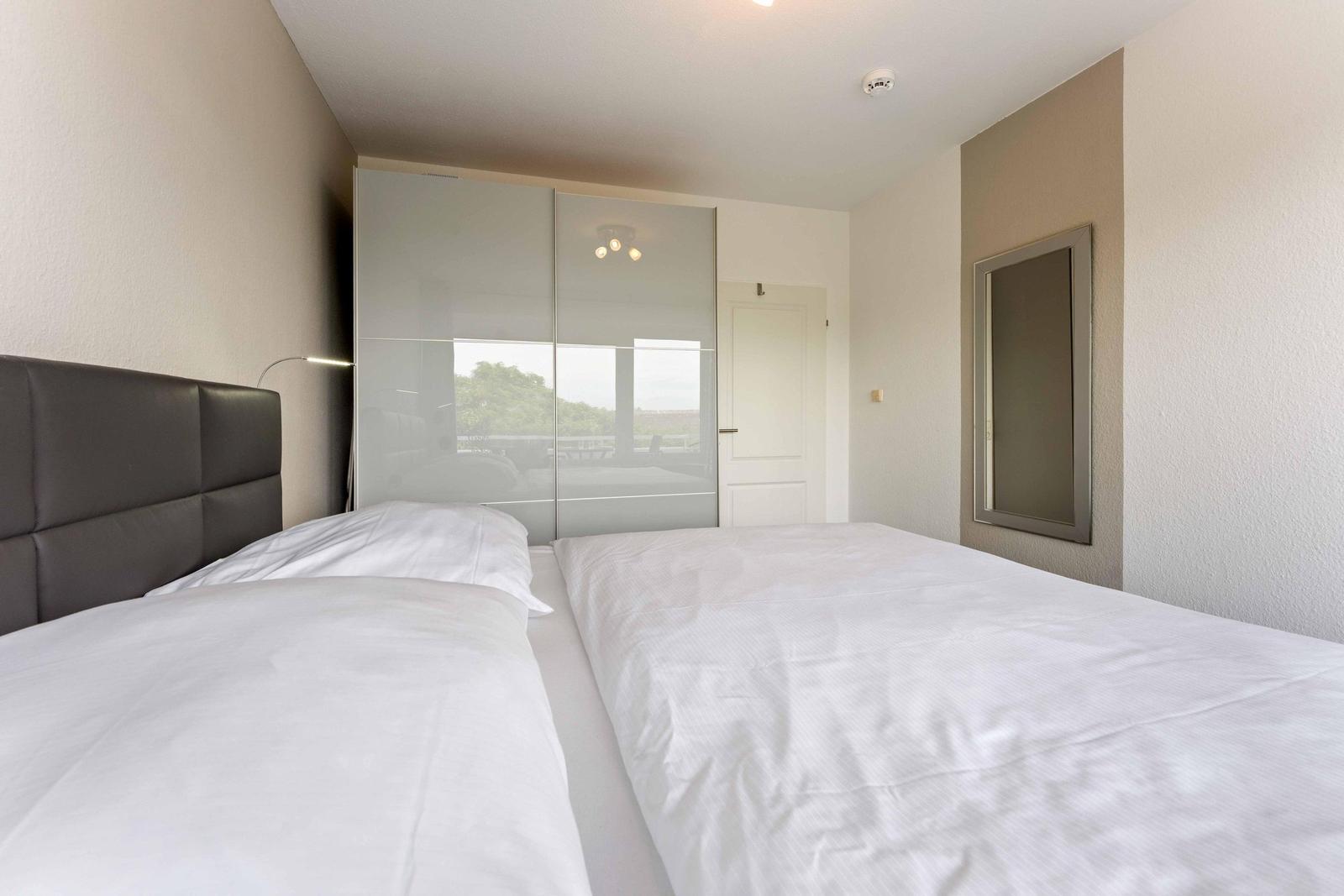 Bedroom with double bed, wardrobe, and mirror