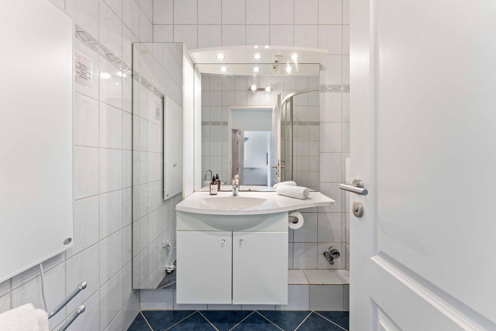 Bathroom with sink, mirror, and shower.
