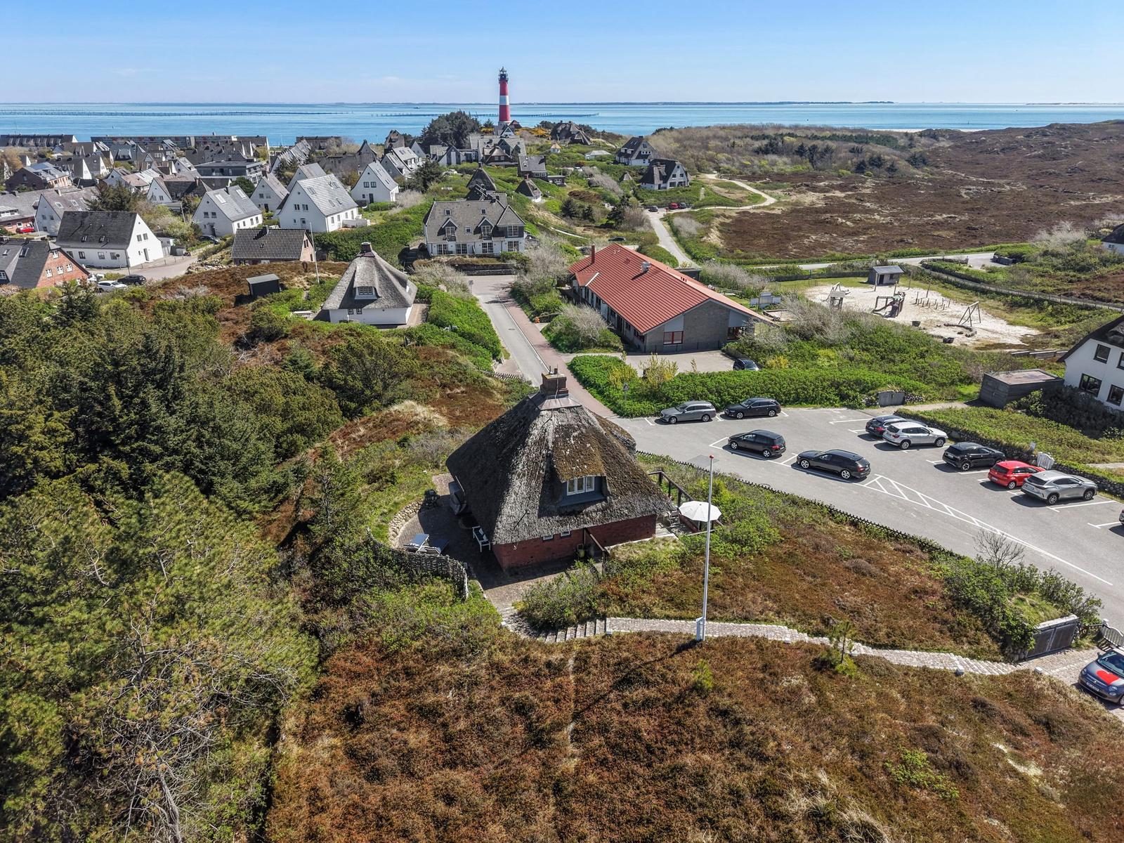 Dorf mit Strand, Leuchtturm und Parkplatz