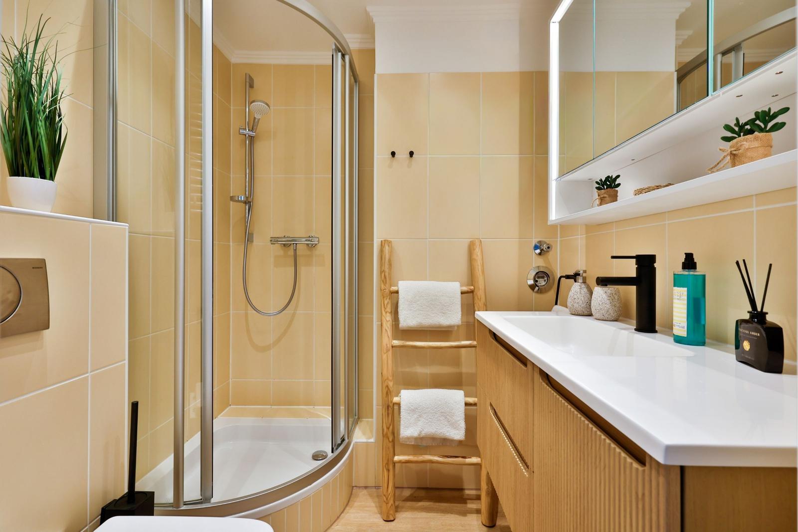 Badezimmer mit Dusche, Waschbecken und Handtuchständer