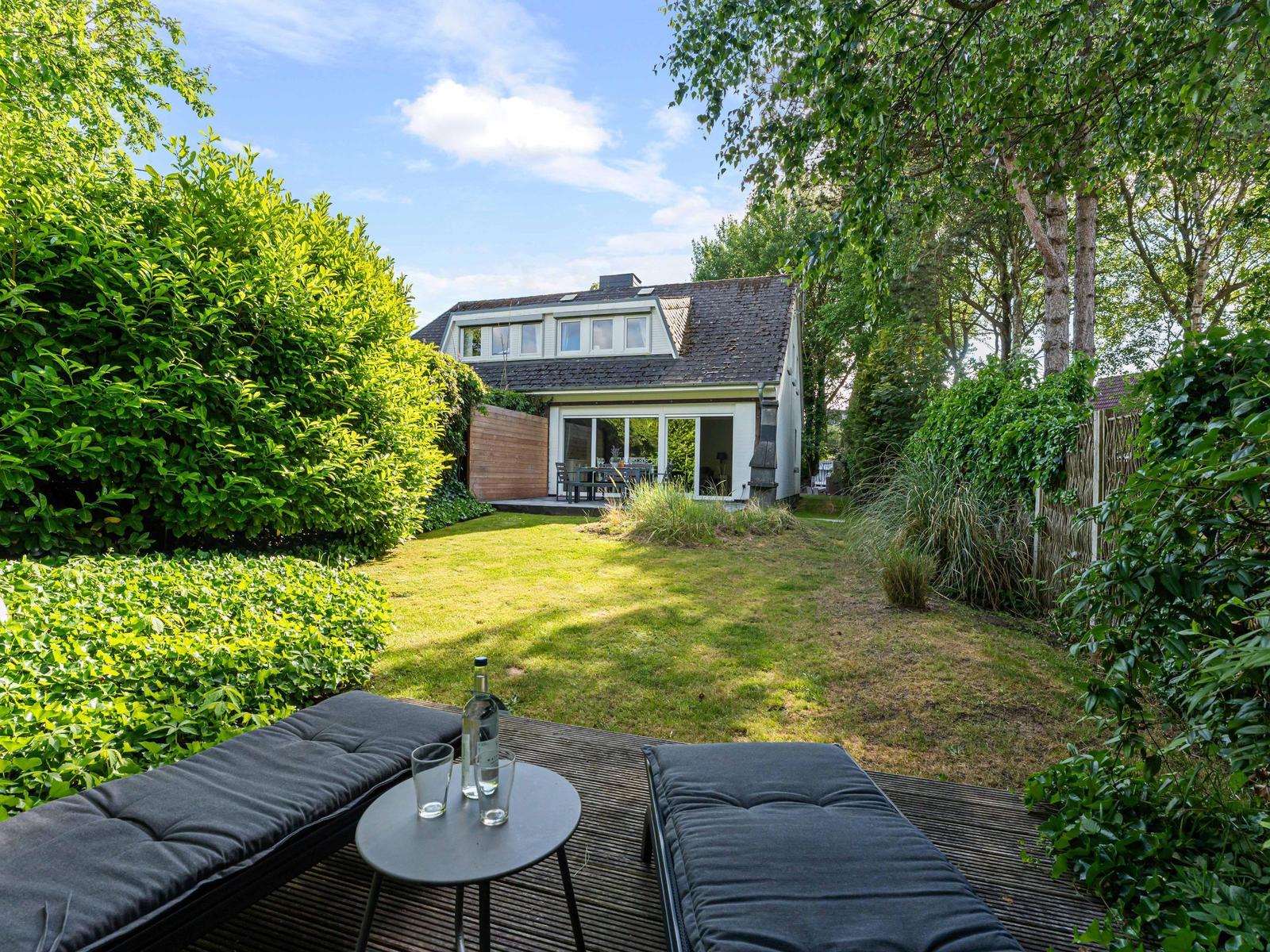 Haus mit Garten, Terrasse und Sitzgelegenheiten im Grünen.