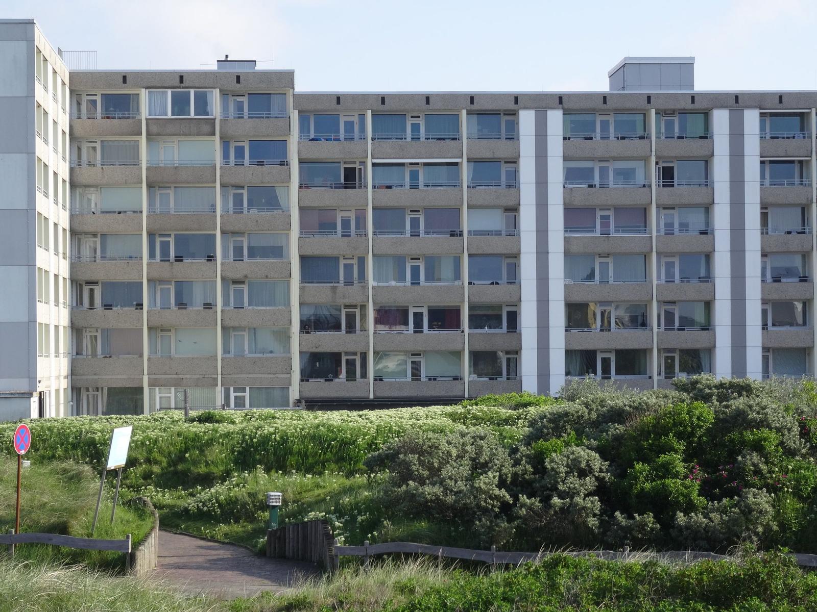 Modernes Mehrfamilienhaus mit Balkonen und grüner Umgebung.