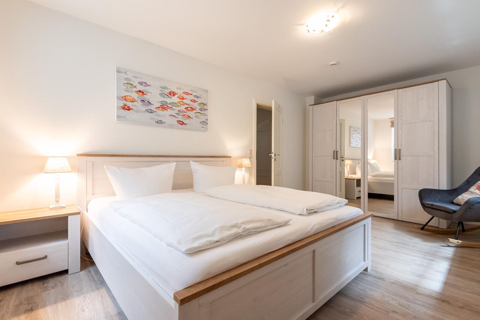 Schlafzimmer mit Doppelbett, Nachttisch und Kleiderschrank.