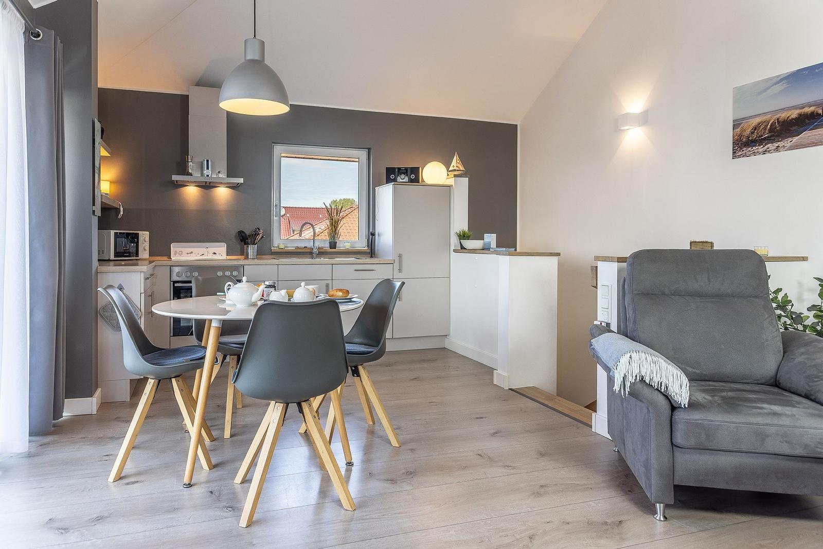 Kitchen with dining table and gray armchair in living area