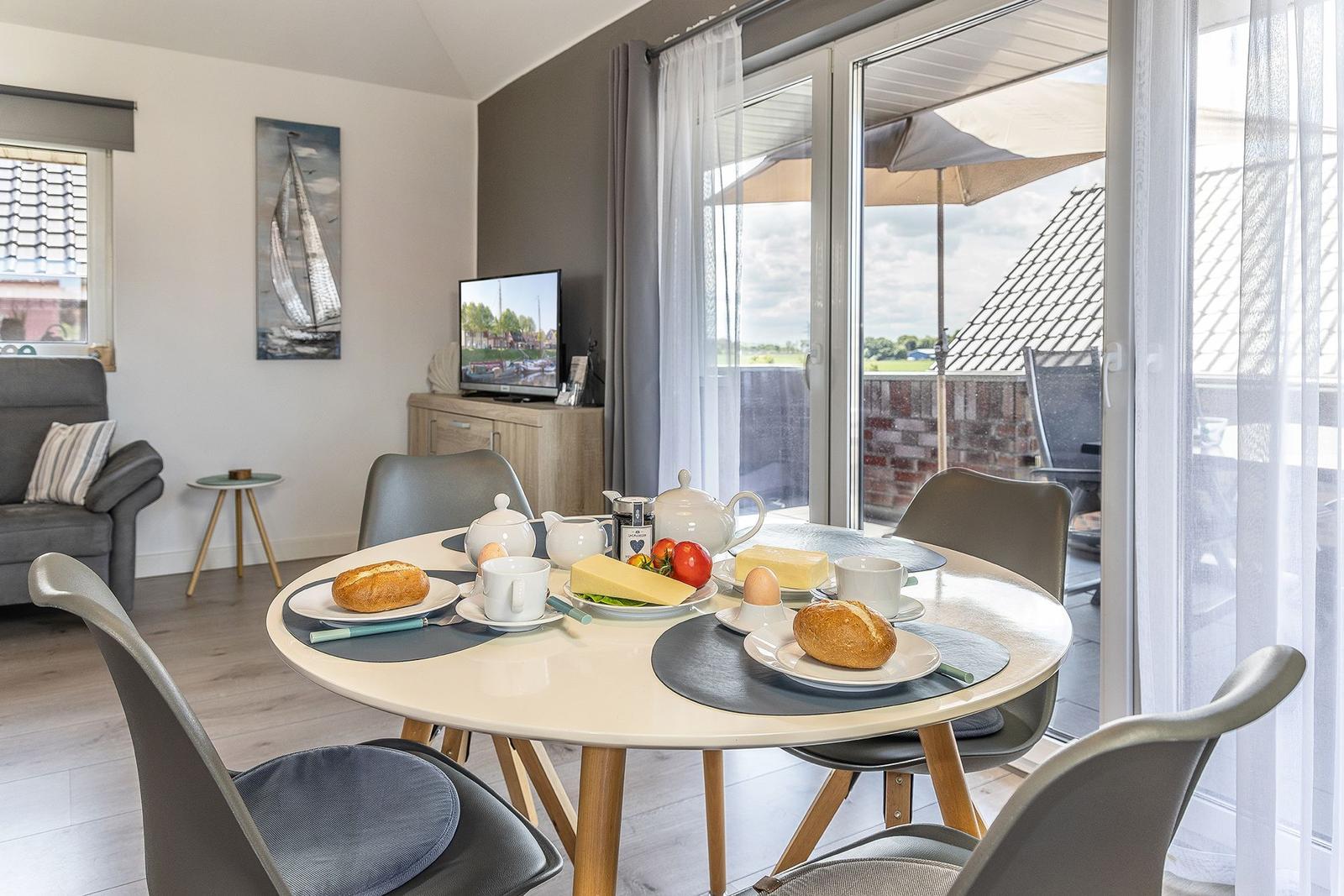 Round table with breakfast, seating, and view of the terrace.