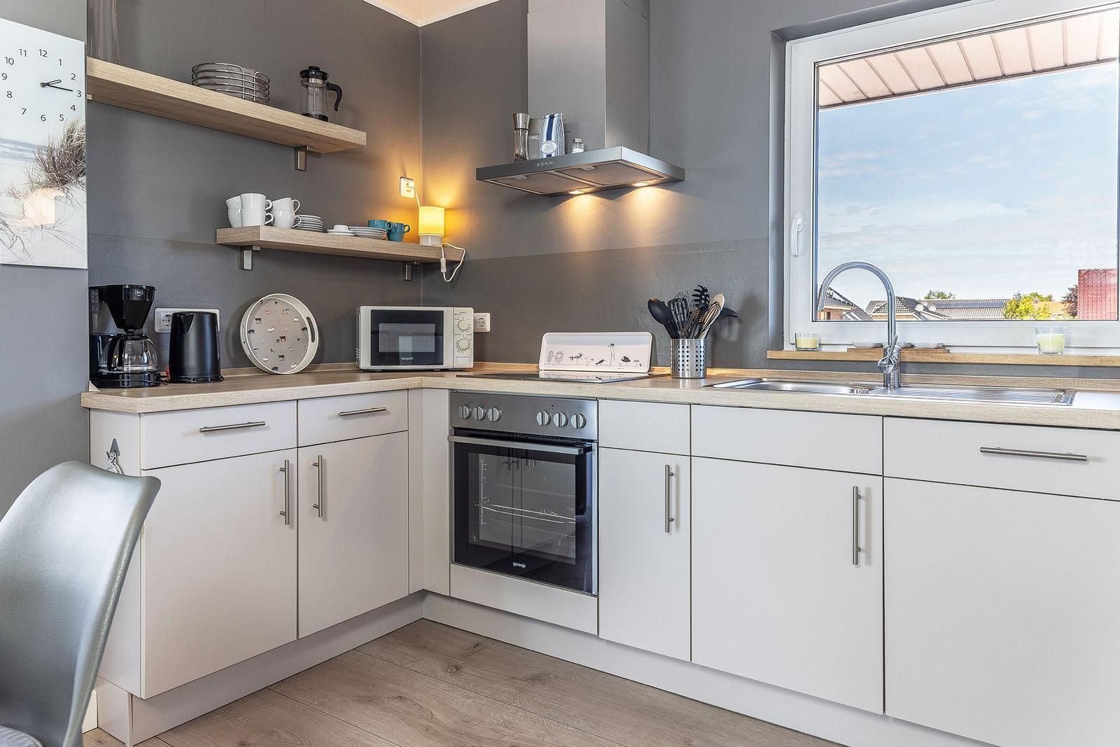Kitchen with white cabinets, stainless steel sink, and view of rooftops.