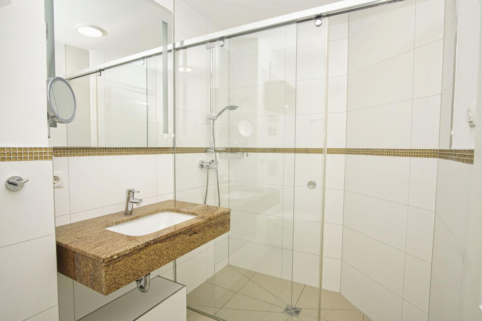 Bathroom with shower, sink, and mirror