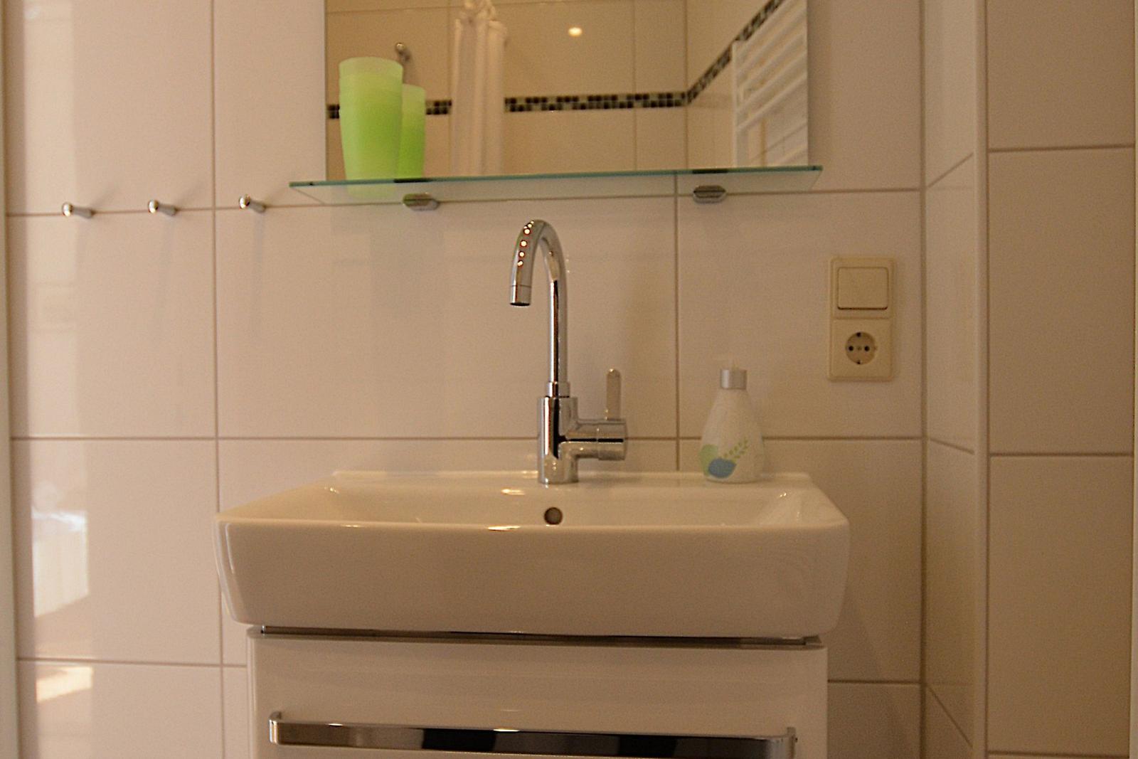 Waschbecken mit Spiegel, Wasserhahn und Seife