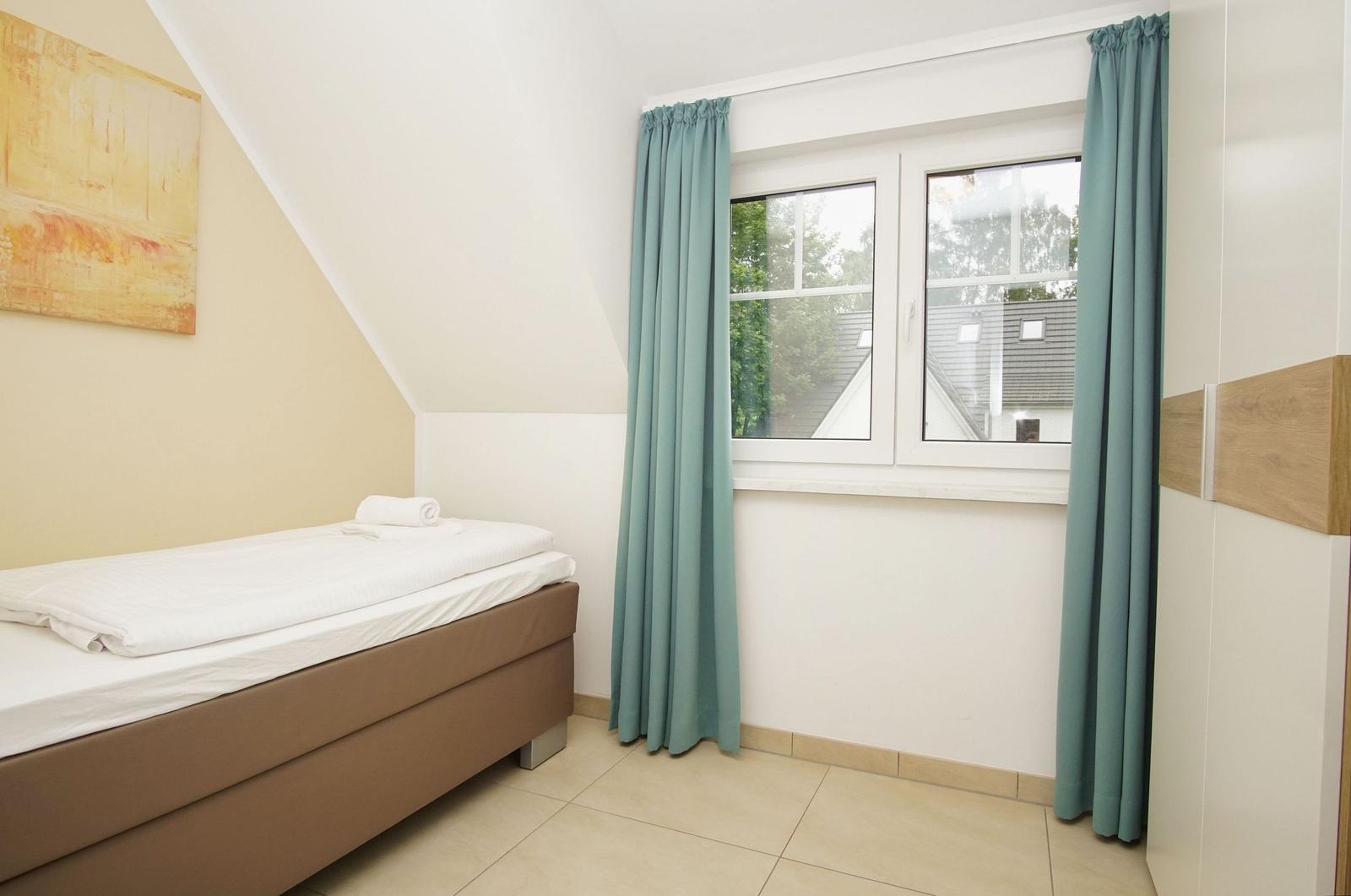 Bedroom with bed, window, and curtains