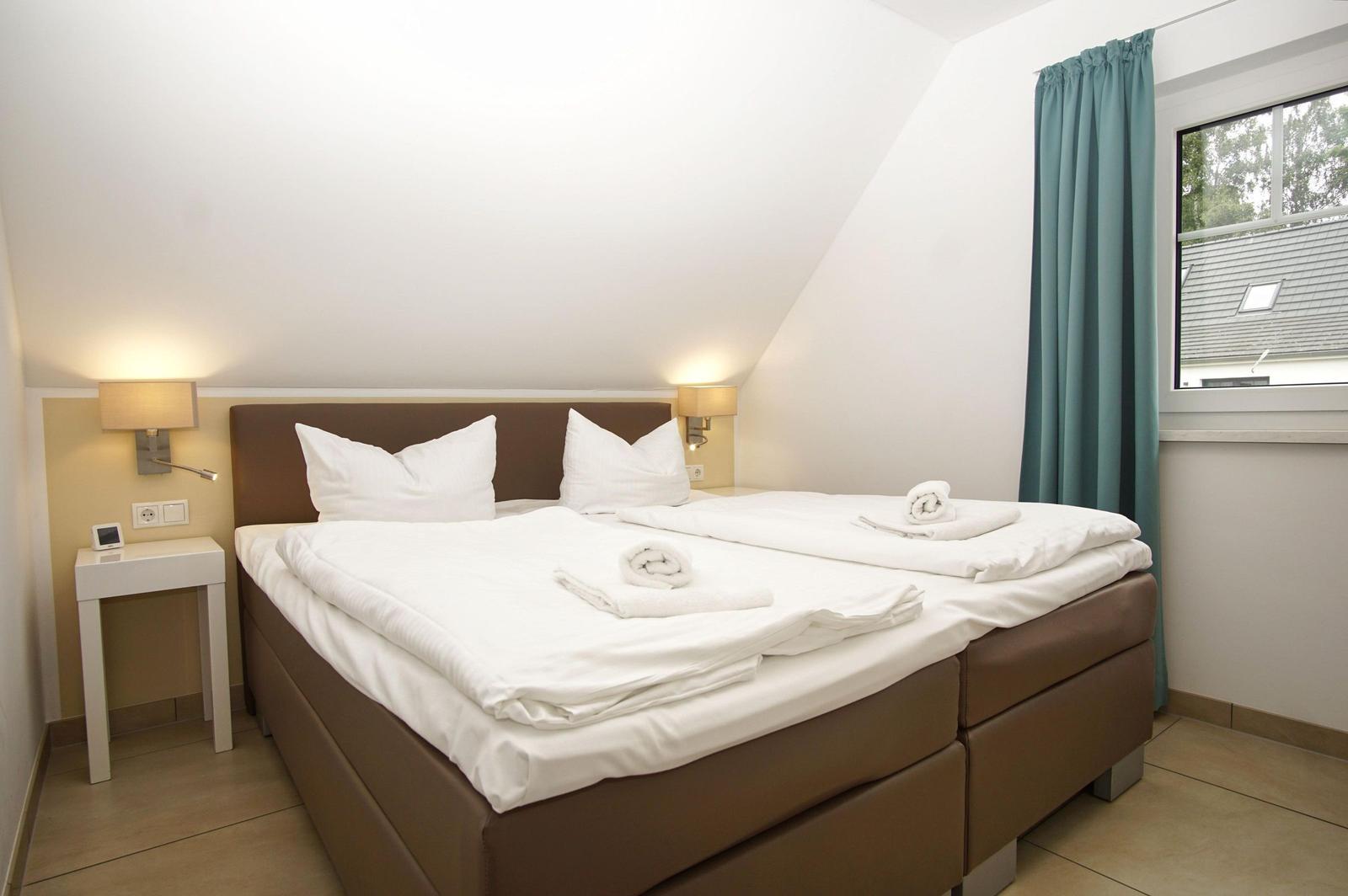 Schlafzimmer mit Doppelbett, Fenster und Nachttisch