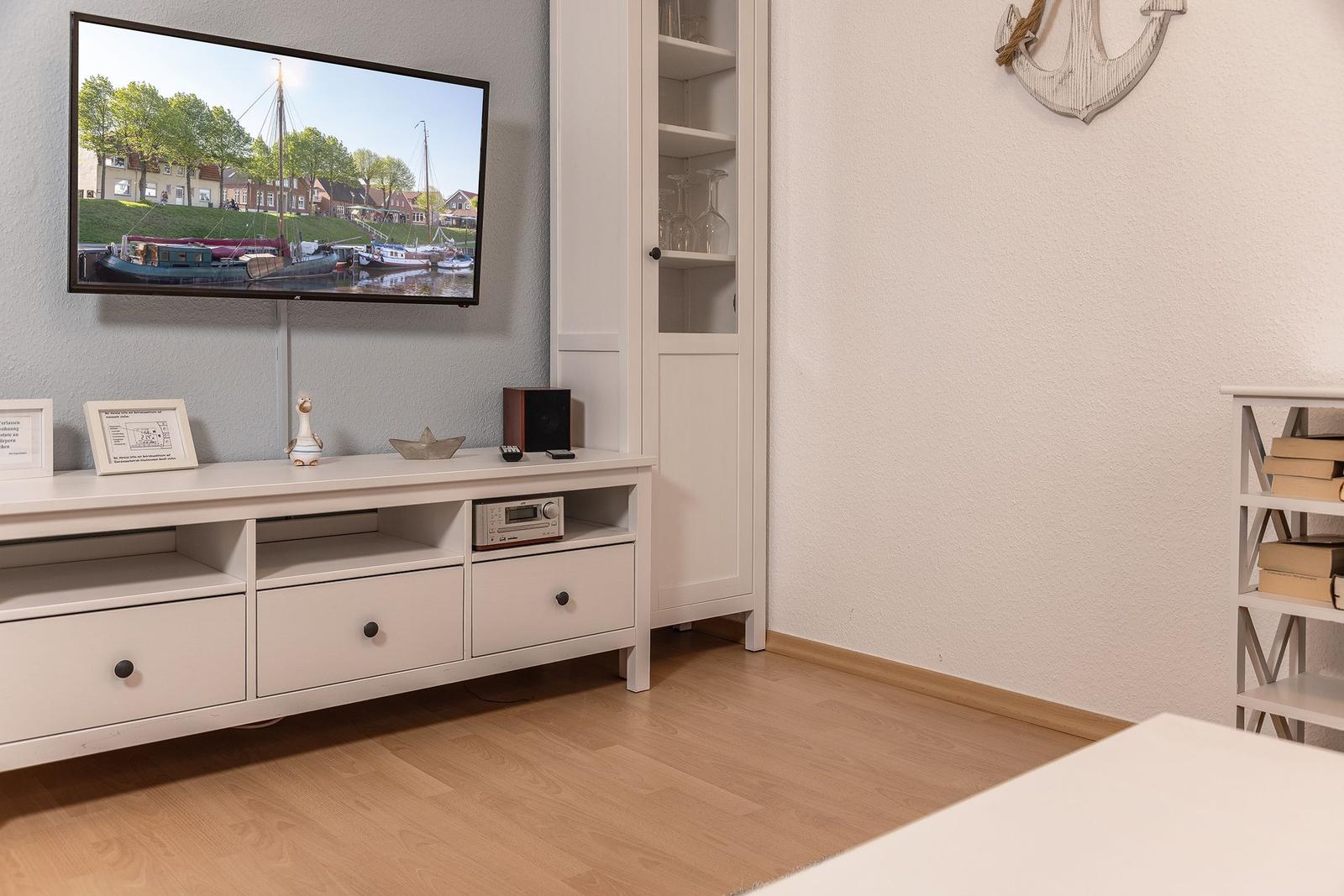 Wohnzimmer mit Fernseher, Sideboard und Bücherregal. Wanddekoration mit Anker.