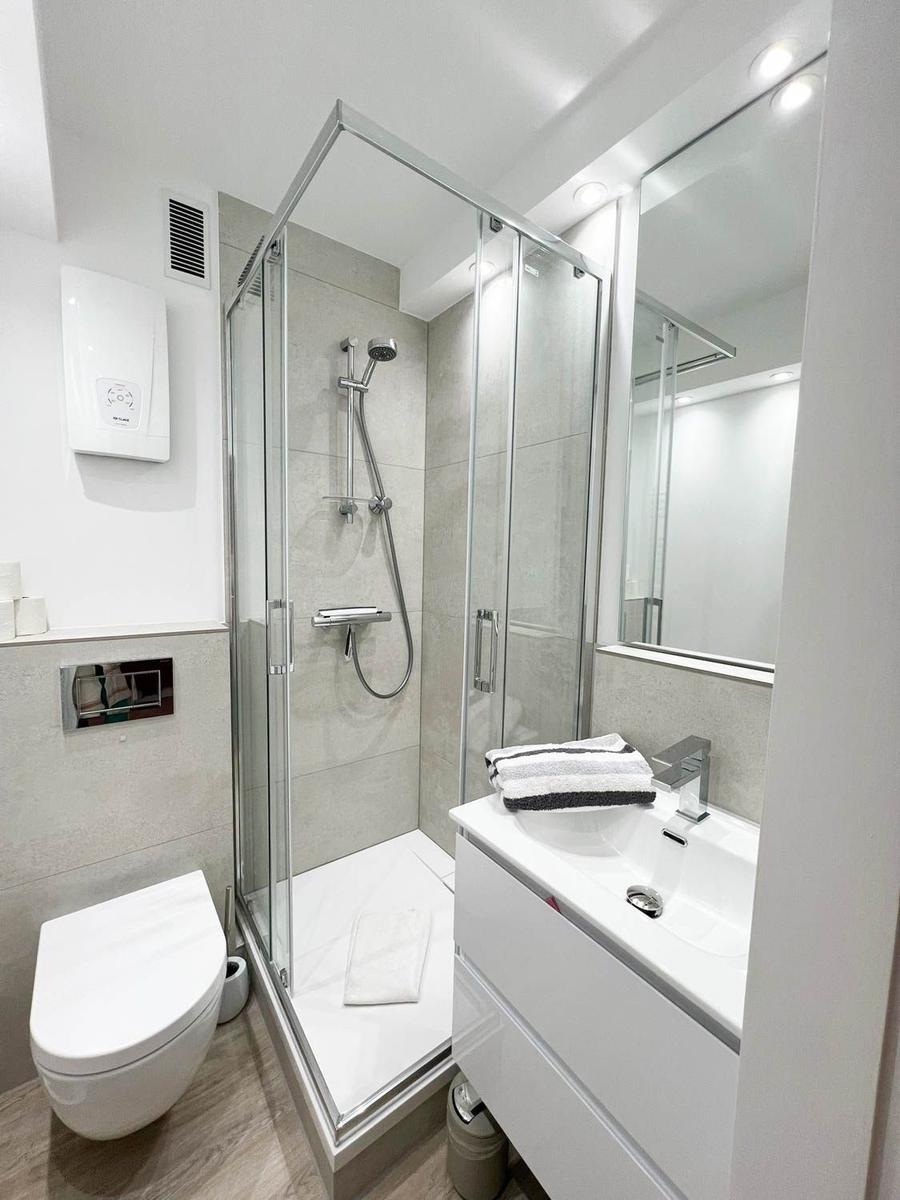 Moderne Badezimmer mit Dusche, Waschbecken und Toilette.