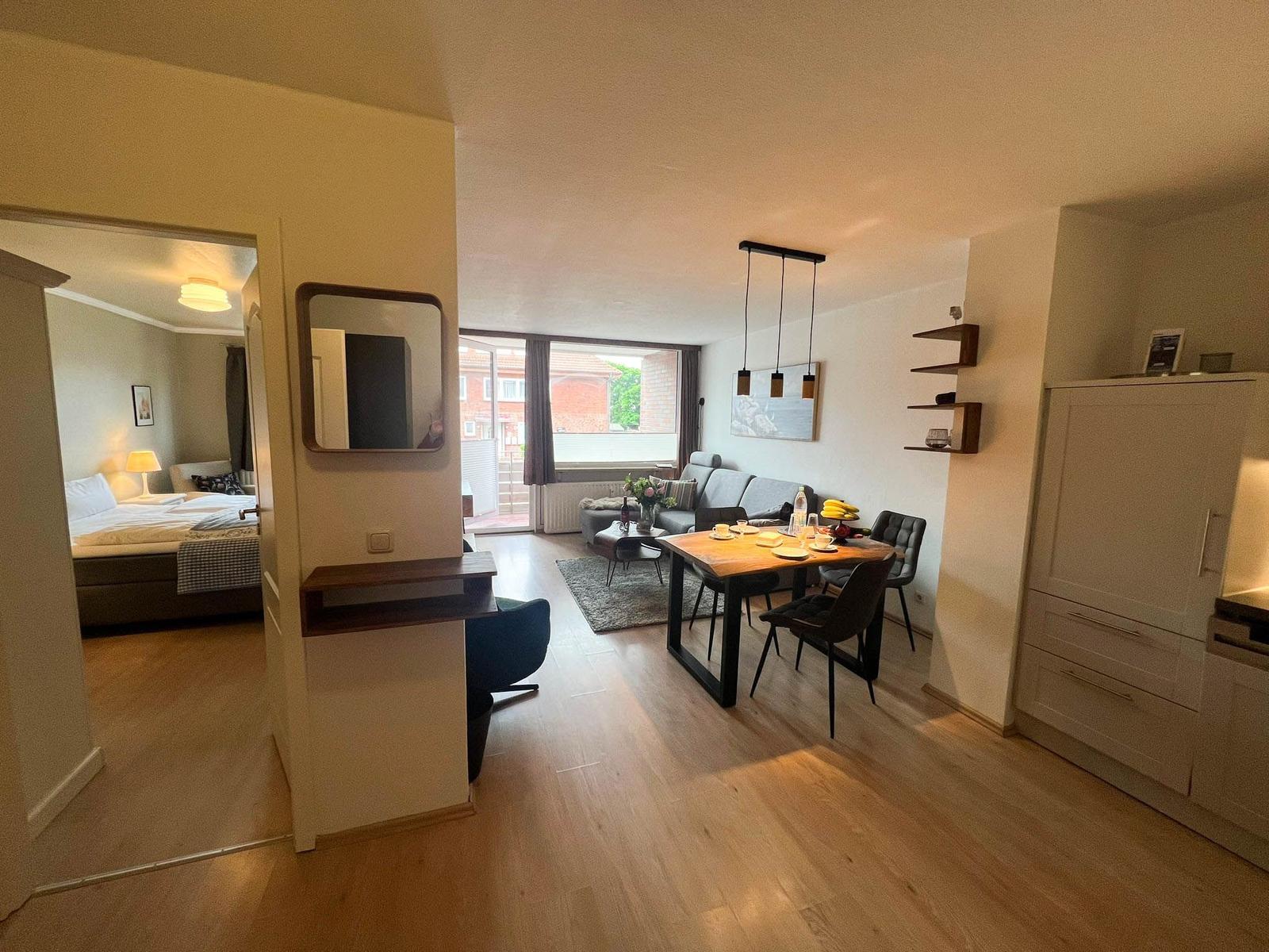 Wohnung mit Essbereich, Wohnzimmer und Schlafzimmer. Holzboden und moderne Einrichtung.