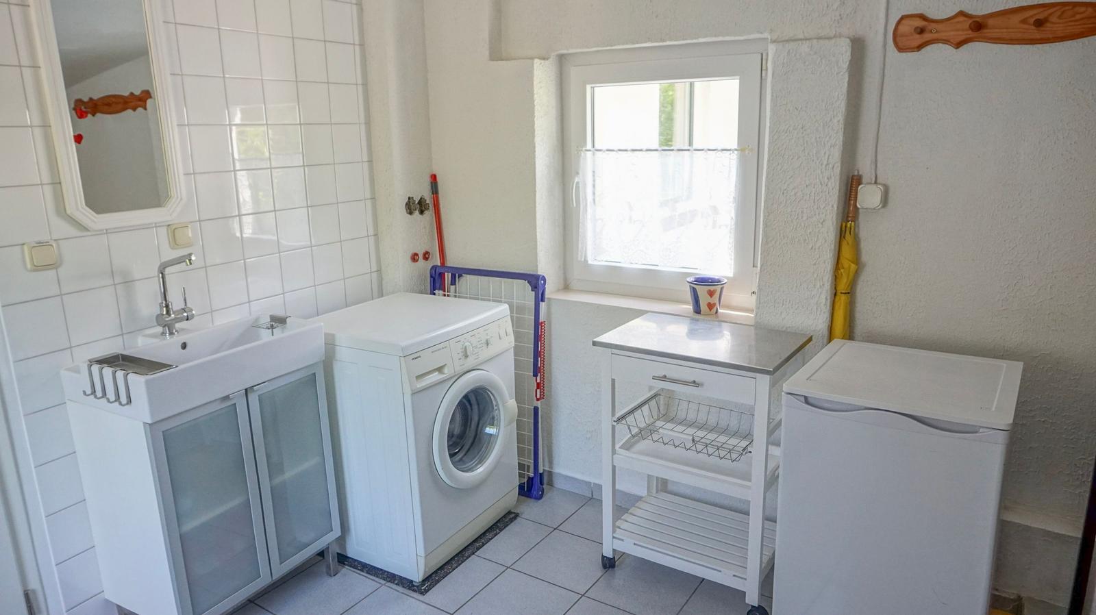 Apartment with washing machine, sink, and refrigerator.