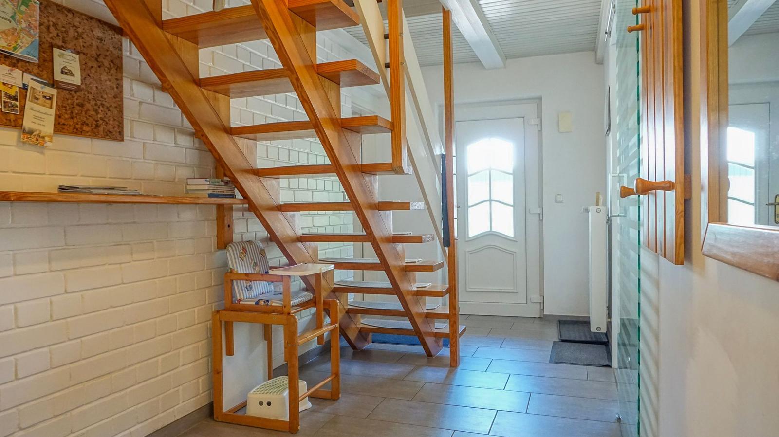 Haus mit Holztreppe, weiße Ziegelwand und Kindersitz
