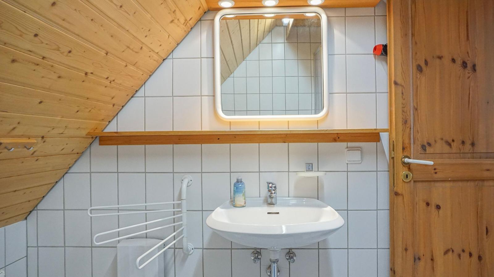 Bathroom with sink, mirror, and wooden ceiling.
