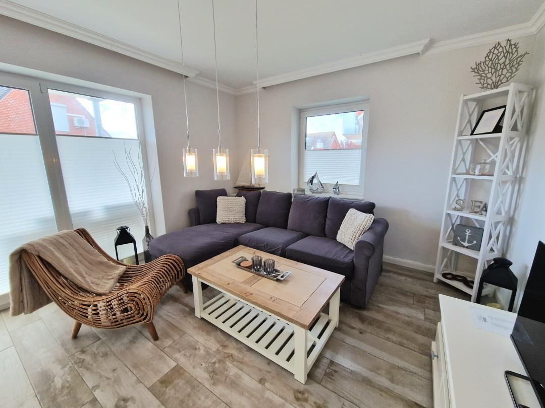 Wohnzimmer mit L-förmigem Sofa, Esstisch und dekorativen Elementen.