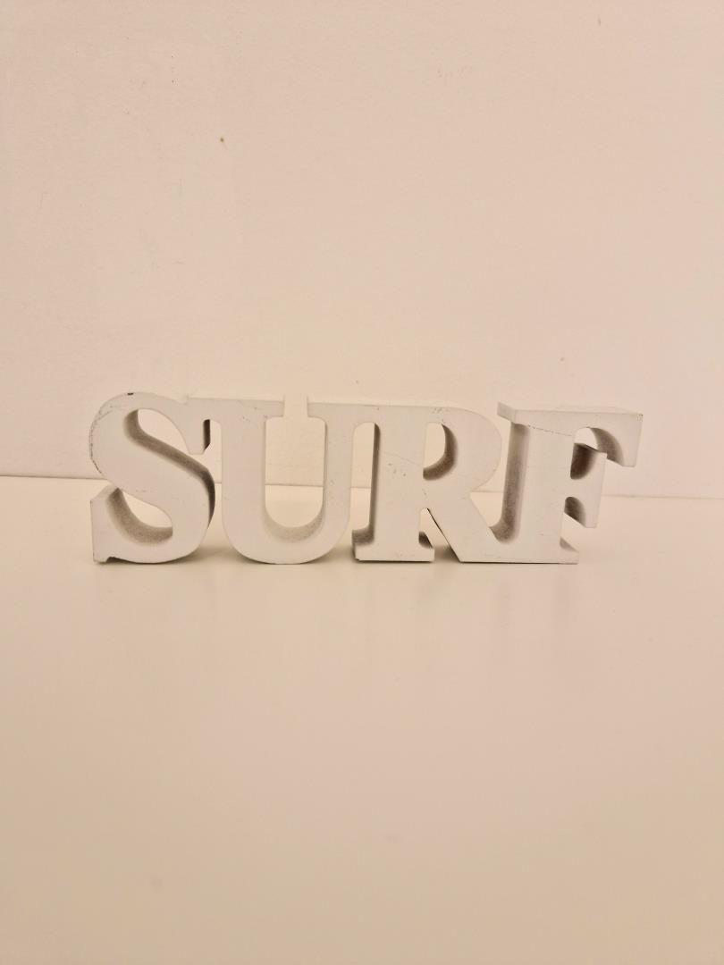 Weißes, dreidimensionales Wort SURF auf einer ebenen Oberfläche.