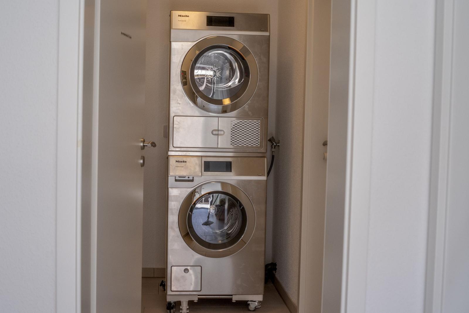 Stacked Miele Wasch- und Trockneranlage in einem schmalen Raum.