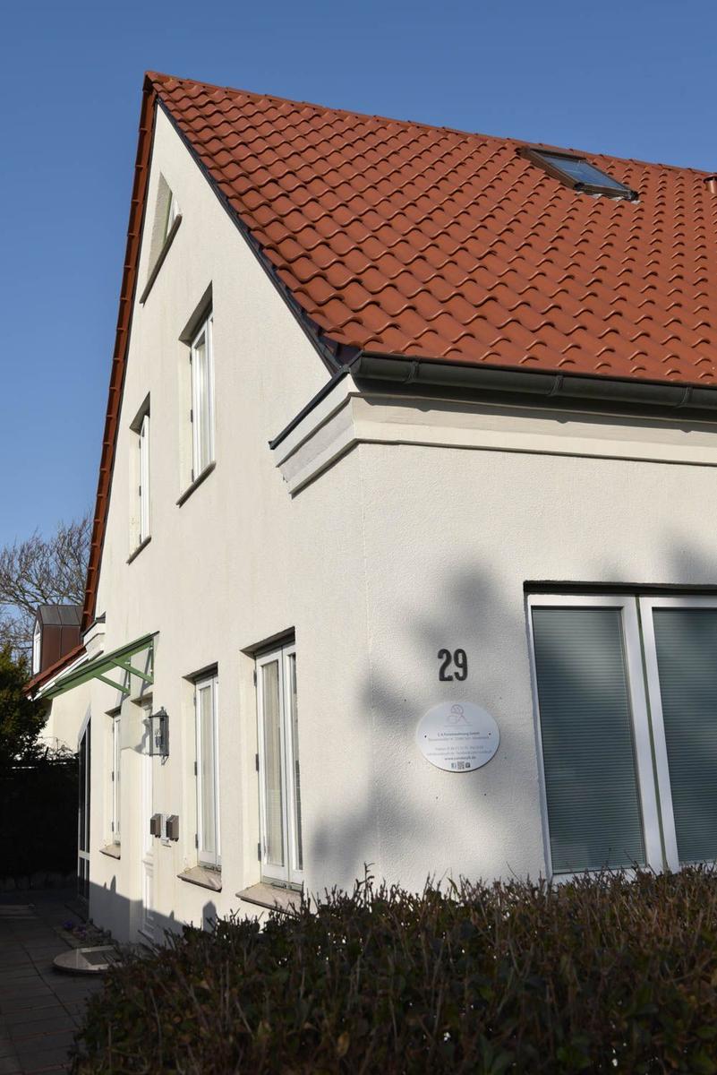 Wohnhaus mit rotem Ziegeldach und weißen Wänden. Hausnummer 29 an der Fassade.