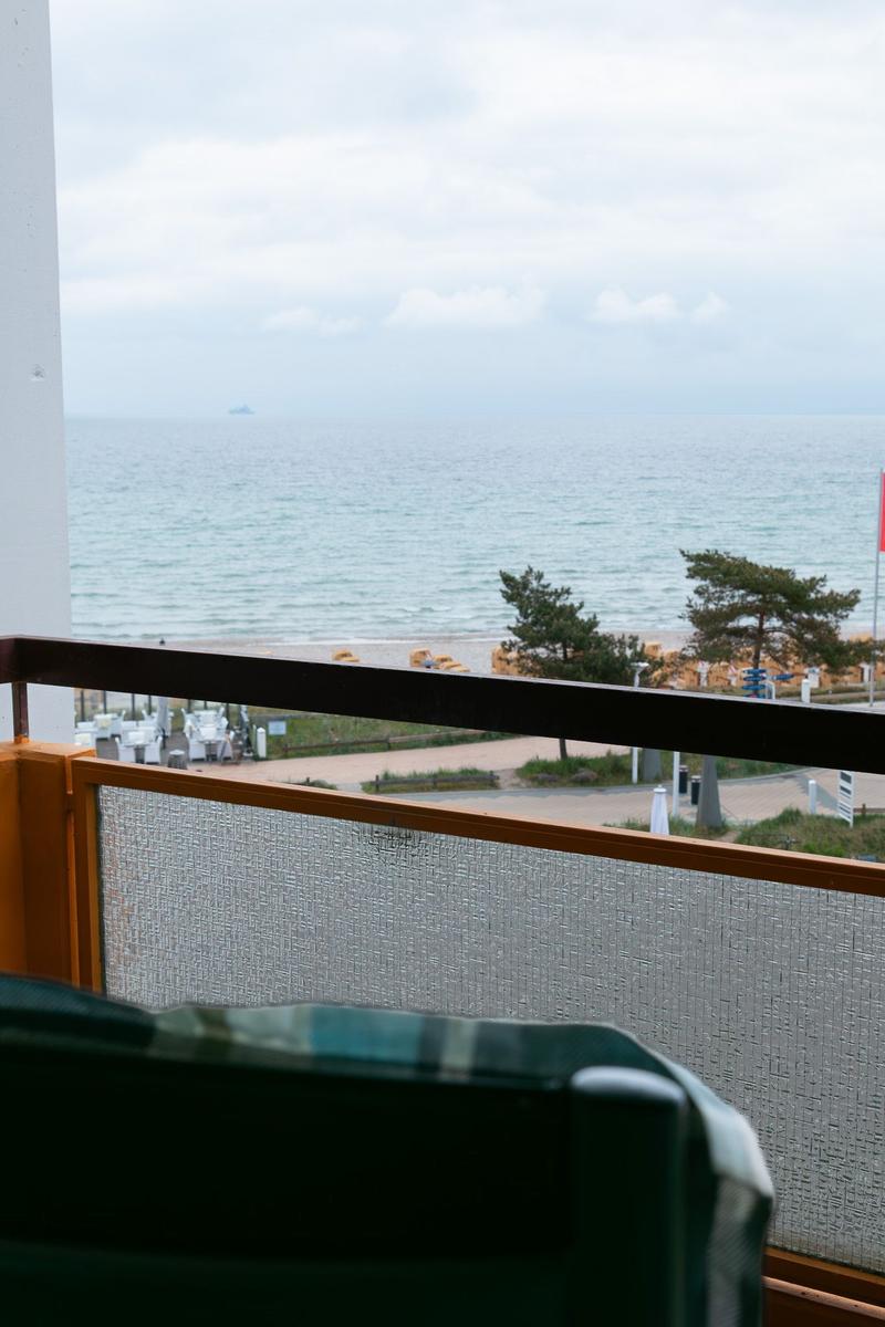 Blick vom Balkon auf das Meer und Strand mit Bäumen