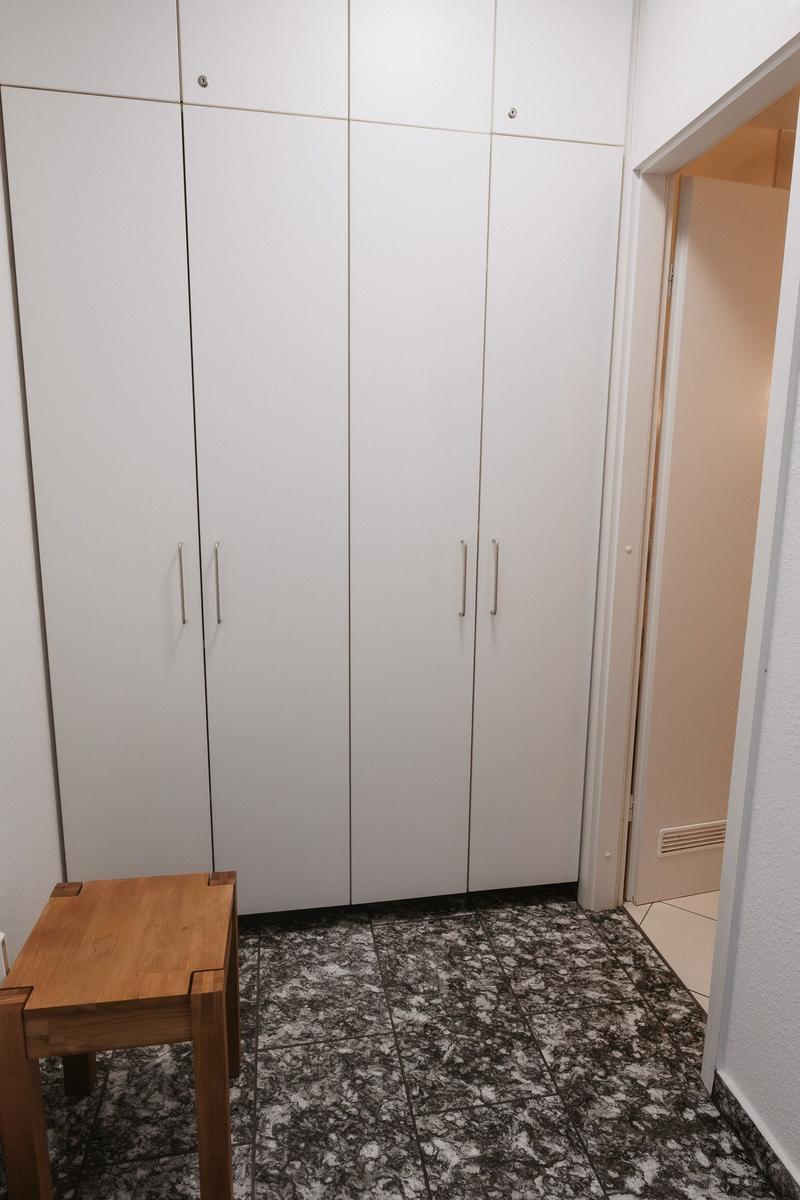 Schlafzimmer mit weißem Schrank und Holztisch auf Marmorfußboden