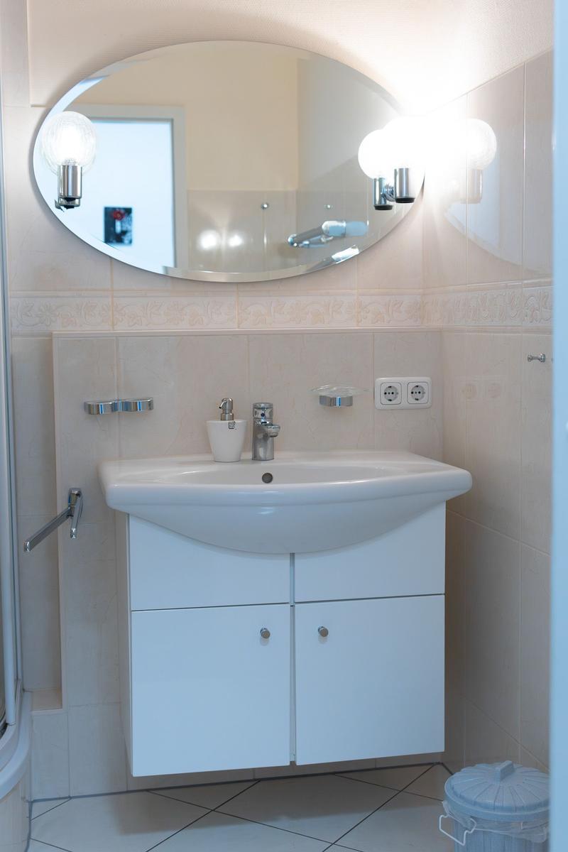 Badezimmer mit Waschbecken, Spiegel und Licht