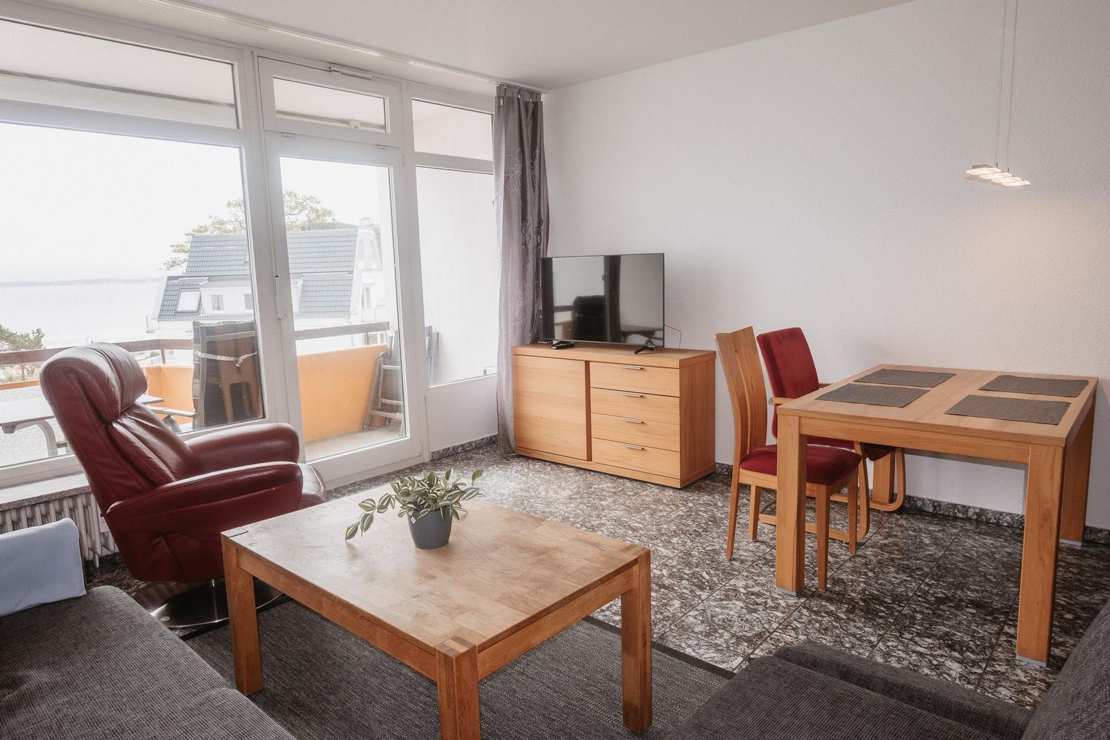 Wohnzimmer mit Essbereich, TV und Blick auf die Terrasse.
