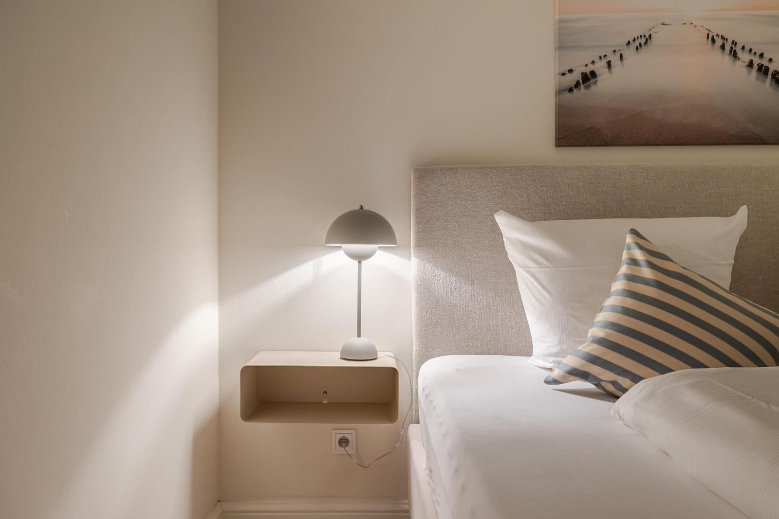 Schlafzimmer mit Bett, Nachttisch und Wandbild