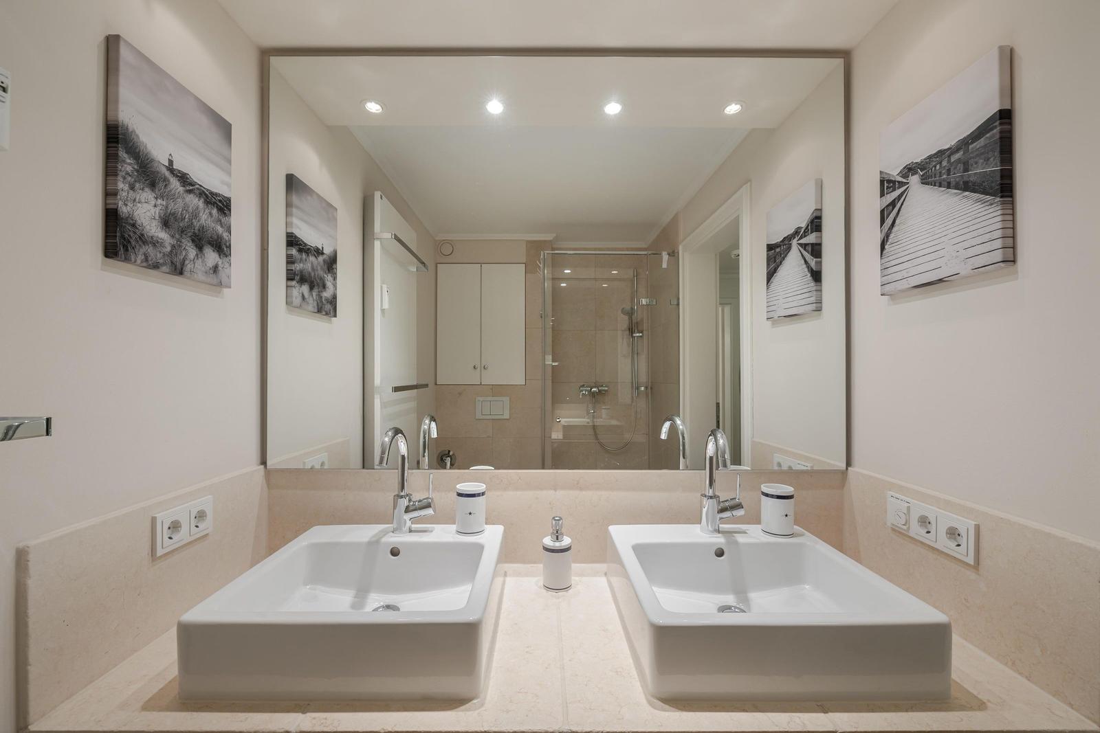 Badezimmer mit zwei Waschbecken, Spiegeln und Dusche.