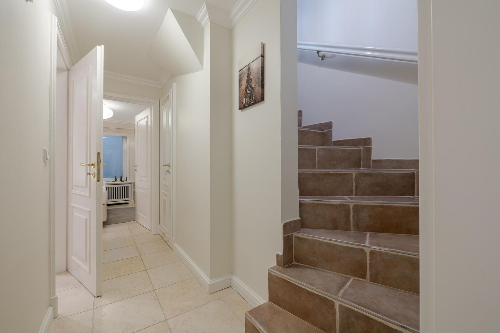 Hallenflur mit Stein-Treppe und geöffneter Tür zum Schlafzimmer