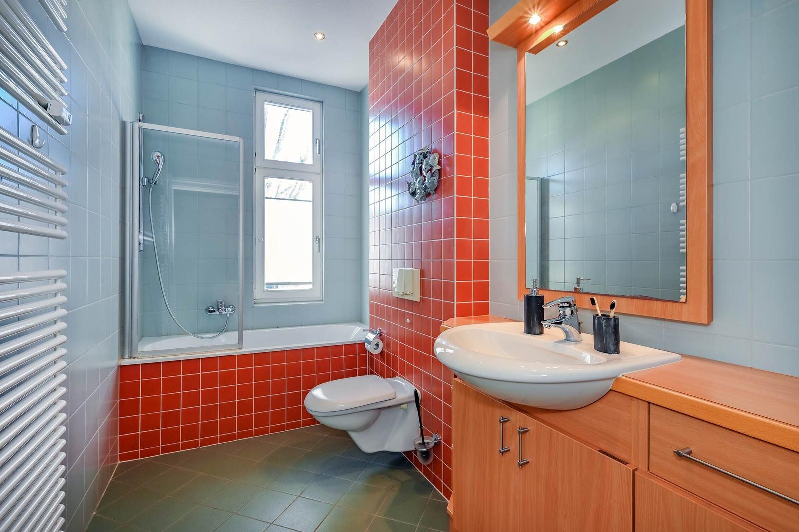 Badezimmer mit Dusche, Toilette und Waschbecken mit Spiegel