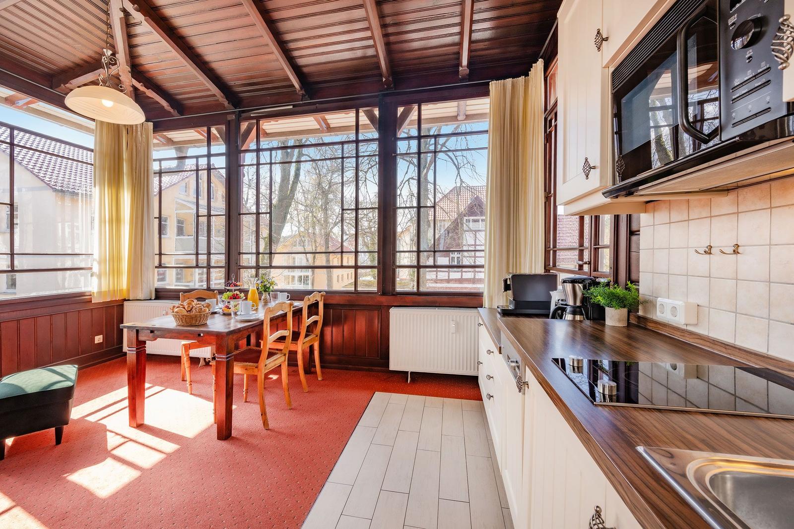 Küche mit Essbereich und großem Fensterblick auf die Straße.