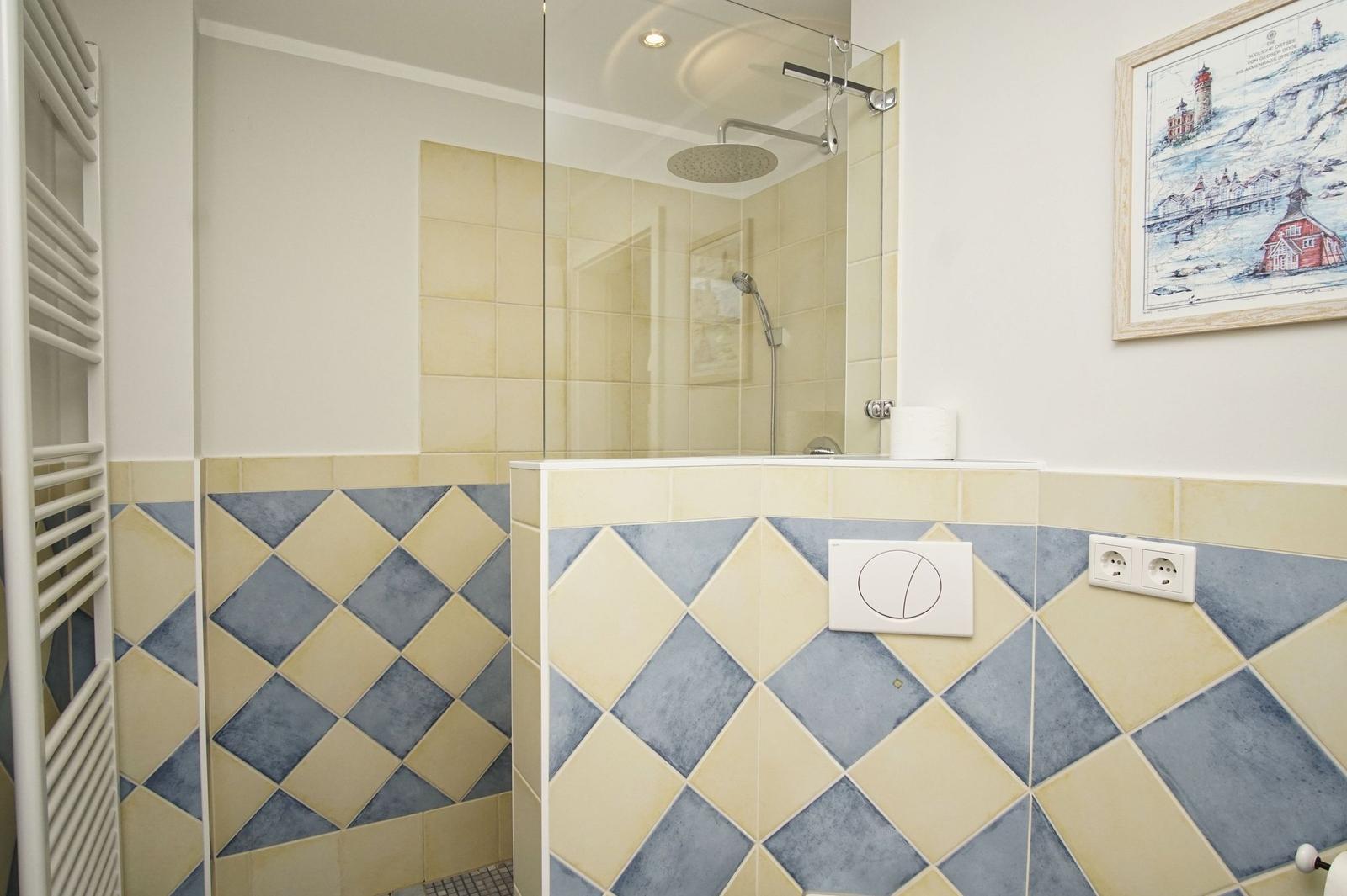 Bad mit Dusche, gefliesten Wänden und Heizkörper
