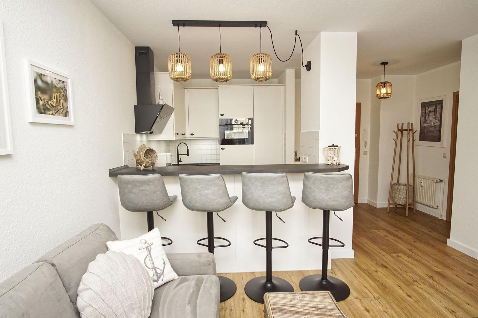 Küche mit Barhocker, Sofa und Holzboden